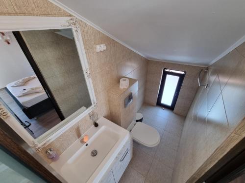 bagno con lavandino, specchio e servizi igienici di CASA MOREANA a Sfântu Gheorghe