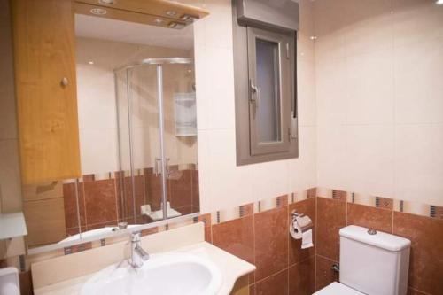 uma casa de banho com um lavatório, um WC e um espelho. em Aranaz bardenas em Cadreita