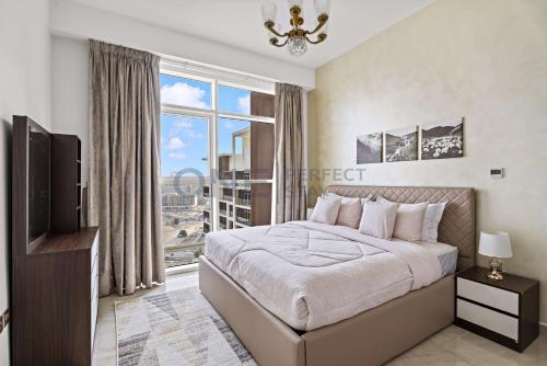 a bedroom with a bed and a large window at 2BHK Gem at Jewelz by Danube in Dubai