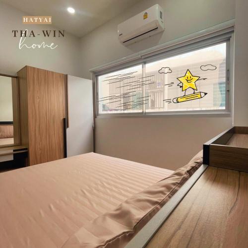 a bedroom with a bed in front of a window at This house is not open right now Tha-win Home-City Charm Adventure with stylish Hat Yai retreat in Hat Yai