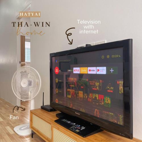 a flat screen tv sitting on top of a table at This house is not open right now Tha-win Home-City Charm Adventure with stylish Hat Yai retreat in Hat Yai