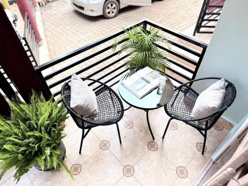 a balcony with a table and chairs and a table and sidx sidx at The Croft Homes -Kampala Buwatte in Wakiso