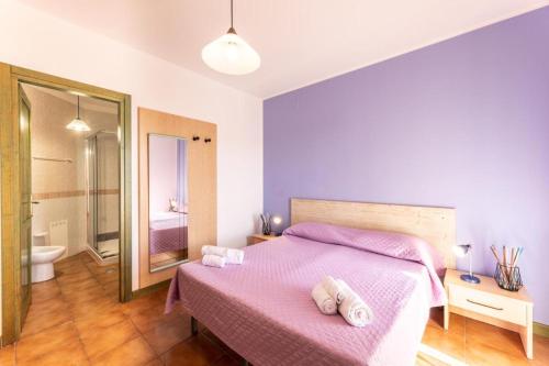 a bedroom with a pink bed and a bathroom at Quaint Residence I Mirti Bianchi n6978 in Santa Teresa Gallura