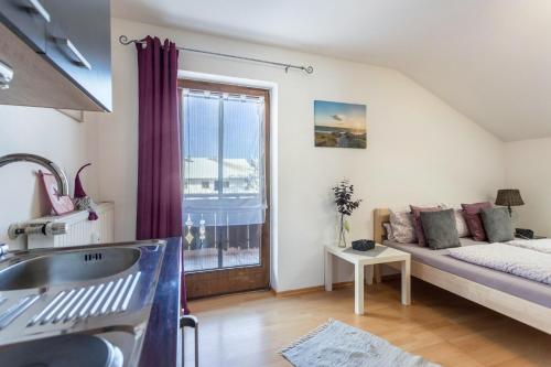 a living room with a bed and a window at Apartment Bergblick in Frasdorf