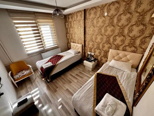 a small bedroom with two beds and a window at Hotel Seven Park in Nevşehir