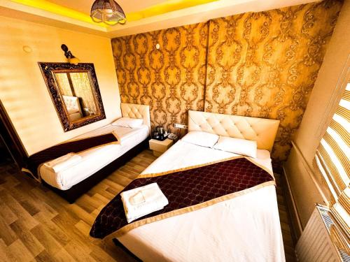 a hotel room with two beds and a mirror at Hotel Seven Park in Nevşehir