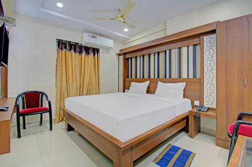 sypialnia z łóżkiem, biurkiem i krzesłami w obiekcie Super OYO Flagship 80823 Hotel Sitara Grand w mieście Visakhapatnam