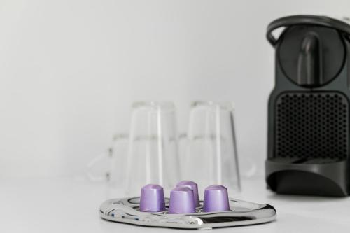 a plate with five purple candles on a counter next to a blender at Maison Bruges in Bruges