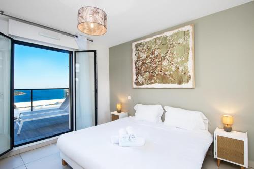 een slaapkamer met een wit bed en een groot raam bij Luxury apartment - Sea View - Private parking in Beausoleil