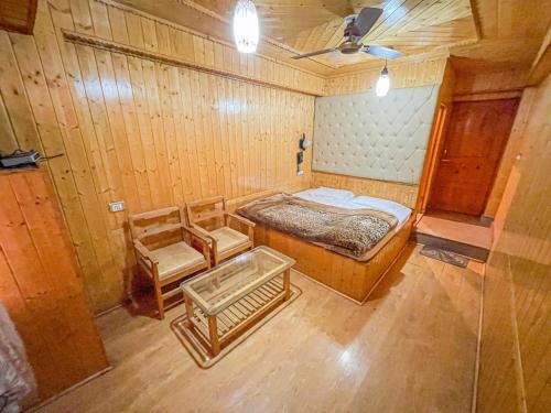 Zimmer mit einem Bett und zwei Stühlen in der Unterkunft HOTEL TOWN PALACE SRINAGAR in Srinagar