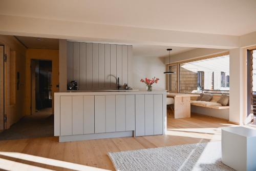 una cocina con una isla blanca en una habitación en MeinNATURGUT mit Sauna, en Oberstaufen
