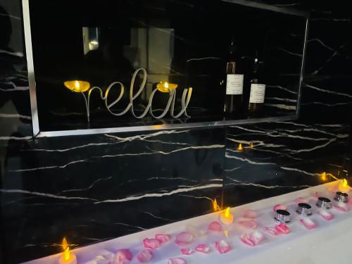 a table topped with pink cookies and wine bottles at Relax Room proche PARIS Porte de Versailles in Malakoff