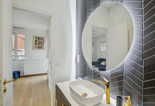 La salle de bains est pourvue d'un lavabo et d'un miroir. dans l'établissement Studio proche paris avec jardin, à Saint-Gratien
