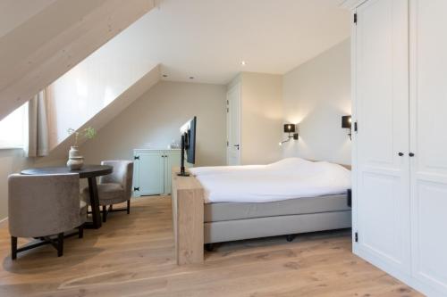 Schlafzimmer mit einem Bett, einem Schreibtisch und einem Tisch in der Unterkunft Zeayou Zeeland - Studio's Zuidstraat 1 in Domburg