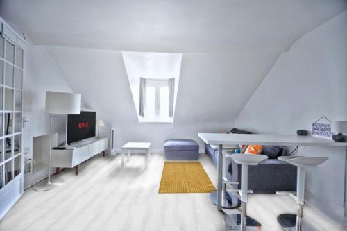 a white living room with a desk and a tv at Promo! near The Pantheon - Latin Quarter! in Paris