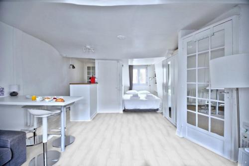 a white living room with a bed and a table at Promo! near The Pantheon - Latin Quarter! in Paris