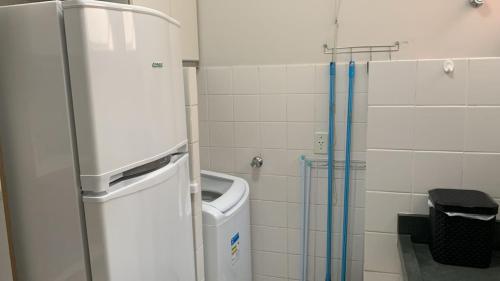 ein Badezimmer mit einem Kühlschrank und einem Mülleimer in der Unterkunft Apartamento inteiro no Alto Umuarama, próximo ao Aeroporto, Medicina e Granja Marileusa. in Uberlândia