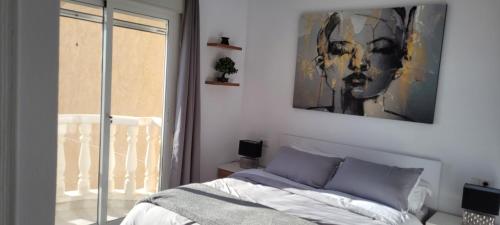 a bedroom with a bed and a painting on the wall at The Triana Townhouse in Ciudad Quesada