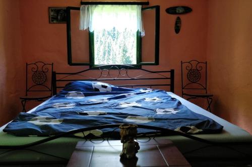 a bedroom with a bed with a blue comforter at Cosy & peaceful cabin off the grid in Mislinja