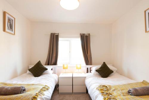 a bedroom with two beds and a window at Bakers House - 4 Bedrooms - Parking for 3 cars - Dogs welcome in Wells next the Sea