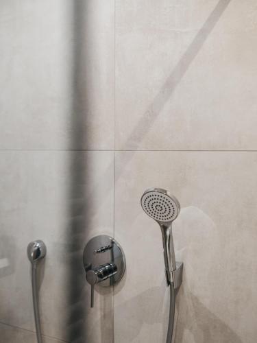 a shower with a shower head in a bathroom at VAYA Nauders inklusive Summercard Basic in Nauders