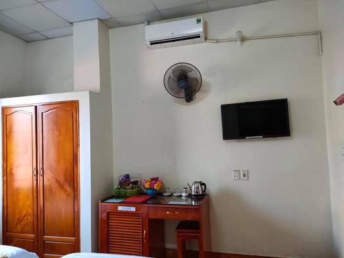 Habitación con armario y TV en la pared. en Nhà Nghỉ Như Ý Ngã 6, en Pho Mới