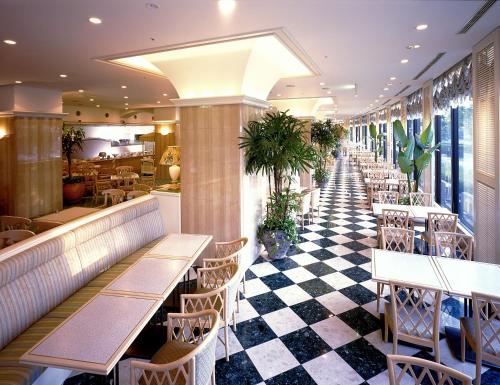 a restaurant with tables and chairs and a checkered floor at Kagoshima Sun Royal Hotel in Kagoshima