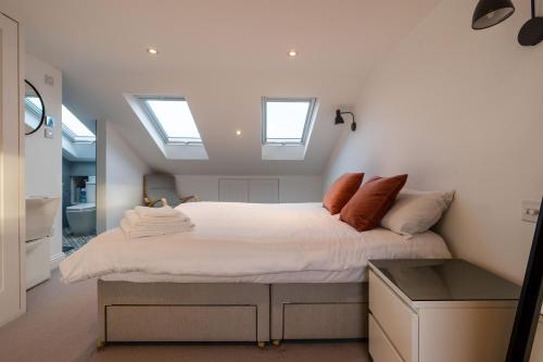 a bedroom with a large bed with skylights at Luxury 3 Bed House in Central Wimbledon Sleeps 7 in London