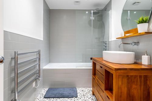 a bathroom with a white tub and a sink at Luxury 3 Bed House in Central Wimbledon Sleeps 7 in London