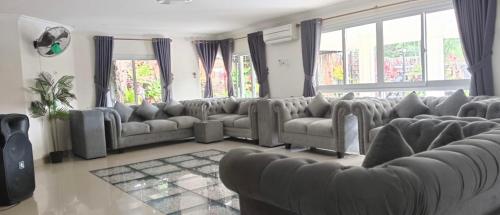 ein großes Wohnzimmer mit Sofas und Fenstern in der Unterkunft Villa London Puncak in Sampal 2
