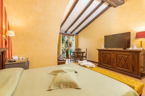 ein Schlafzimmer mit einem großen Bett und einem TV in der Unterkunft Hotel Arbatasar in Àrbatax