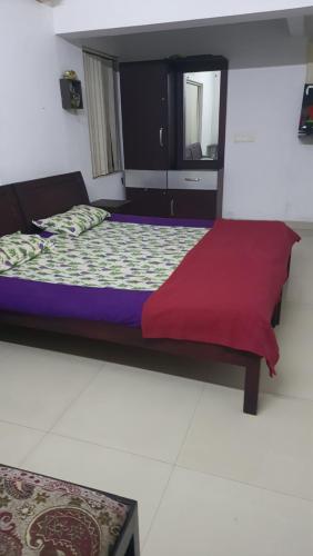 a bedroom with a bed with a red blanket at ABRU'S Holidays International in Alleppey