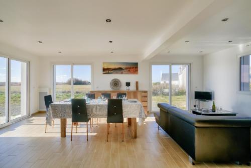 une salle à manger avec une table et un canapé dans l'établissement Séjour breton à 7 avec vue sur le phare d'Eckmühl, à Penmarcʼh