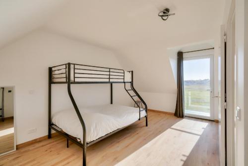 - une chambre avec des lits superposés en métal et une fenêtre dans l'établissement Séjour breton à 7 avec vue sur le phare d'Eckmühl, à Penmarcʼh