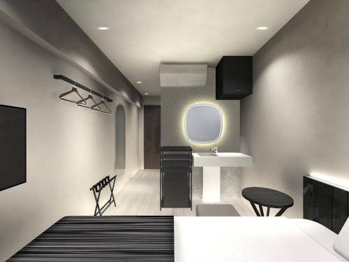 a bedroom with a bed and a sink and a mirror at Hotel TAU, Kumamoto in Kumamoto