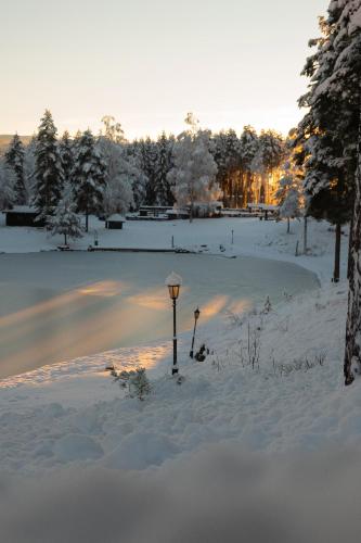 a street light in the snow next to a road at Hunderfossen Hotel & Resort in Hafjell