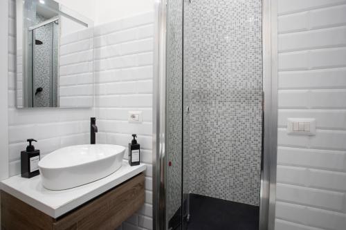 a white bathroom with a sink and a shower at 2 Passi Da in Rome