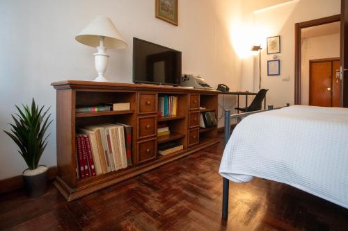 a bedroom with a television on a book shelf at 2 Passi Da in Rome