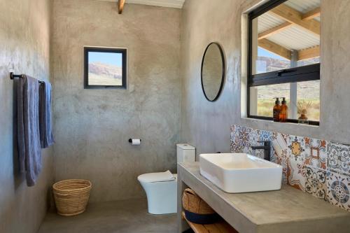 ein Bad mit einem Waschbecken und einem Spiegel in der Unterkunft Alpha Excelsior Guest Farm in Cederberg