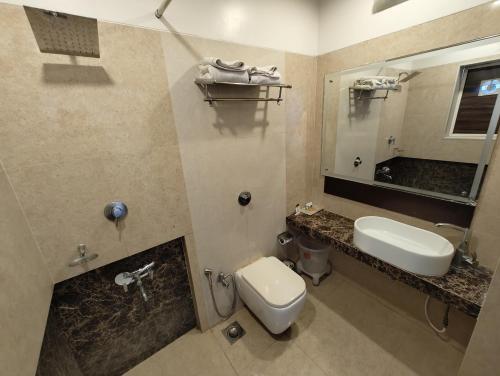 y baño con lavabo, aseo y espejo. en Divine Boutique Hotel Panchgani, en Panchgani