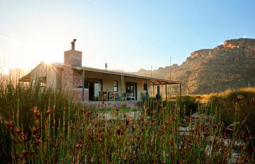 ein kleines Haus mit einem Berg im Hintergrund in der Unterkunft Alpha Excelsior Guest Farm in Cederberg