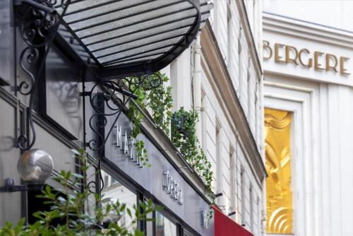 un bâtiment avec un panneau sur son côté dans l'établissement Hôtel Maxim Opéra, à Paris