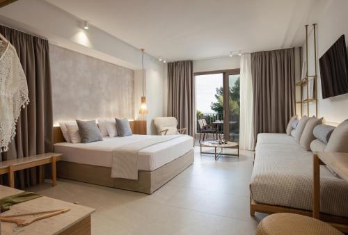 une chambre d'hôtel avec un lit et un canapé dans l'établissement Philoxenia Hotel, à Psakoudia