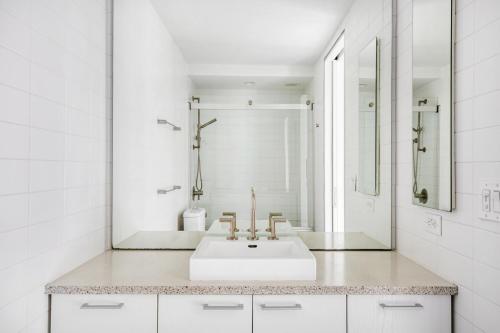 a white bathroom with a sink and a mirror at E Village 1br w gym wd doorman nr Union Sq NYC-278 in New York