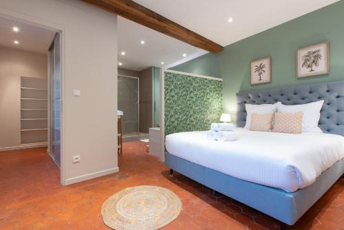 a bedroom with a large bed and a walk in shower at Escale de Giulia in Beaune