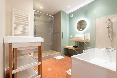 a bathroom with a tub and a sink and a shower at Escale de Giulia in Beaune