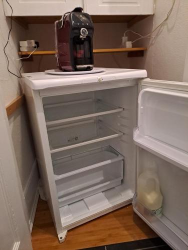 a kitchen appliance sitting on top of an empty refrigerator at Lantern Guest House in Edinburgh