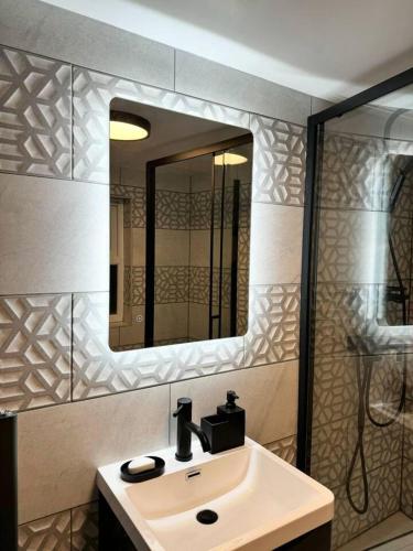 uma casa de banho com um lavatório e um espelho em Elegant 2-Bedroom Apartment near city centre em Birmingham