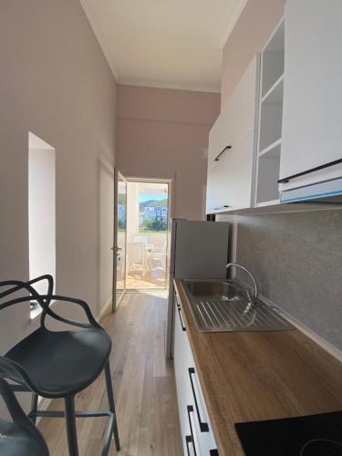 una cocina con una silla negra y una barra en Tea Residence, Gjiri i Lalzit Apartments en Durrës