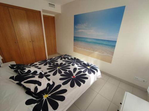 1 dormitorio con 1 cama en blanco y negro con una foto de la playa en Team019 Cambrils Blau Residencial España, en Cambrils